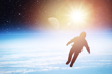 Silhouette of an astronaut in space against the backdrop of the planet. Elements of this image furnished by NASA