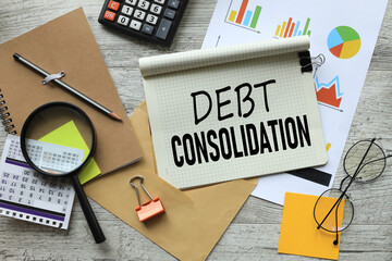 debt consolidation stationery and calculator on financial chart. text on notepad page with spiral