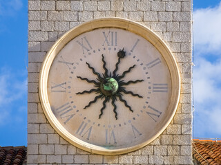 Clock on the bell tower in Dubrovnik, Croatia - ancient round clock with roman numerals and 12...