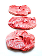 Three uncooked boneless lamb leg steak on white background. Premium high quality meat product of agriculture industry. Butcher craft and skill. Food supply chain.