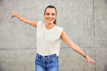 Adult woman having fun dancing isolated against concrete wall