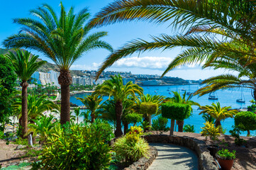 Fototapeta na wymiar Beautiful aerial landscape of Anfi del Mar resort surrounded by palm trees on the coastal cliffs in the summer holiday, Gran Canaria, Canary Islands, Spain