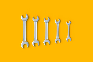 Row of wrenches of different sizes on orange background. Metal spanner in workshop. Repair and maintenance tool. 3d render