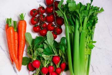 Fresh vegetables, carrots, radishes, celery stalks, cherry tomatoes.top veiw