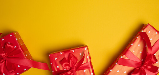 Gift box tied with a red bow on a yellow background