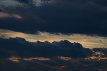 Dark evening sky. Bad weather. Fluffy clouds. Light breaks through the clouds. Universal horizontal photo. The background picture.