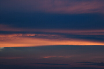 Bright blue clouds at sunset. Yellow lines, romantic sky. Light breaks through the clouds. Universal photos. The background picture.