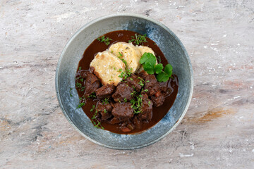 Traditionelles deutsches geschmortes Hirschragout mit Gemüse und Semmelknödel in süß würziger...