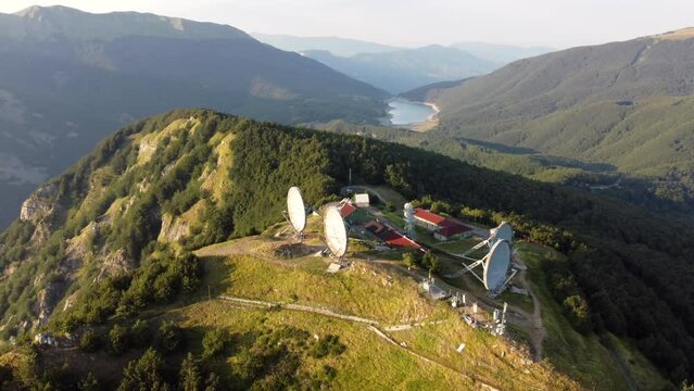 Aerial view of the big parabolic antenna of the radio station abandoned on the top of Monte Giogo, used during cold war. Comano, Massa and Carrara province, Lagastrello lake, Tuscany, Italy. 