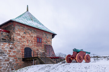 Towers of Akershus castle in Oslo. Cannon on the embankment, tower from brick visible. Cloudy...