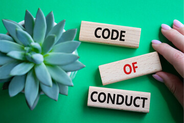 Code of conduct symbol. Wooden blocks with words Code of conduct. Beautiful green background with...