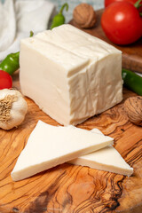 Full fat cow cheese. Fresh feta cheese on cutting board. Close up