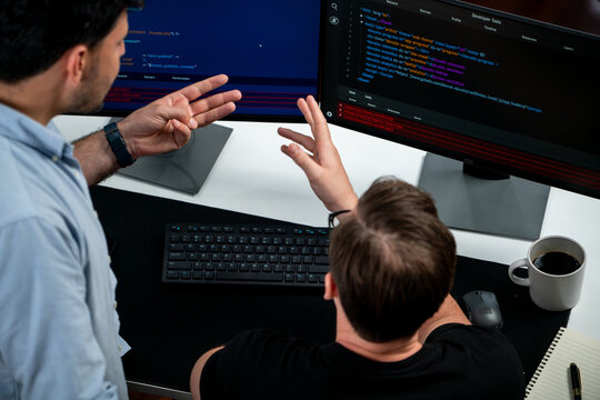 IT developers discussing online software development information on pc screen, creating program coding for latest version application on website. Concept of brainstorming firmware updated. Sellable.