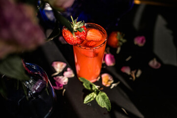 Strawberry juice in a glass on a black background. Selective focus.