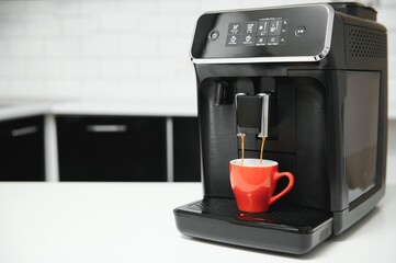 Modern espresso coffee machine with a cup in kitchen