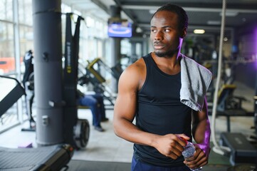 happy young african man drinking water after exercise