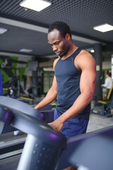 Black African American young man doing cardio workout at the gym