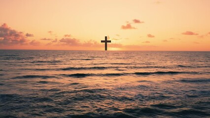Silhouette of Christian cross in the ocean at sunset