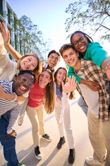 Vertical multiracial group of teenagers taking a selfie looking front camera laughing and having...