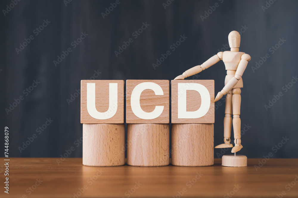 Poster there is wood cube with the word ucd. it is an abbreviation for user centered design as eye-catching