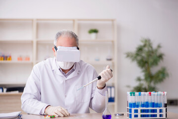 Old male chemist wearing virtual glasses