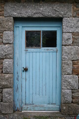 old wooden door in a granit stone wall