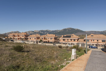 Fototapeta na wymiar An urbanization of semi-detached single-family homes of various heights next to a mountain range