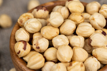peeled roasted hazelnuts in a wooden bowl, close-up
