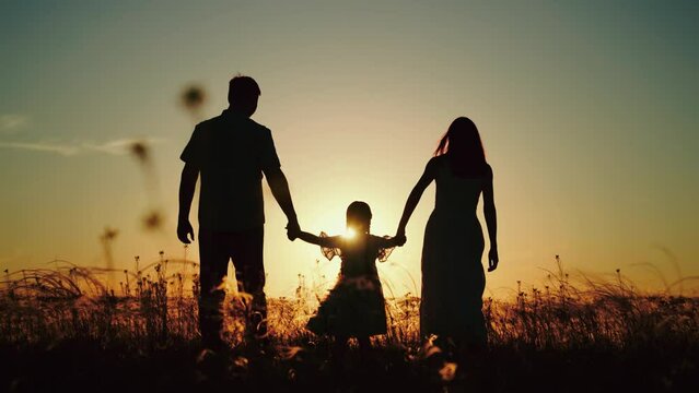 Man and wife take girl to field to practice family yoga. Man with beloved wife walking in fresh evening air of park with little daughter. Man with wife and daughter finally gets out for walk