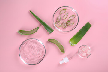 Flat lay composition with aloe vera leaves and cosmetic gel on pink background