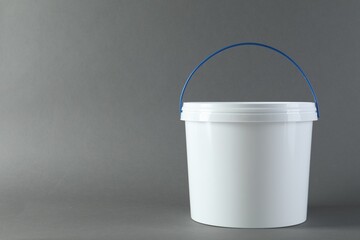 One plastic bucket with lid on grey background. Space for text © New Africa