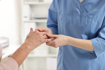 Arthritis symptoms. Doctor examining patient's hand in hospital, closeup