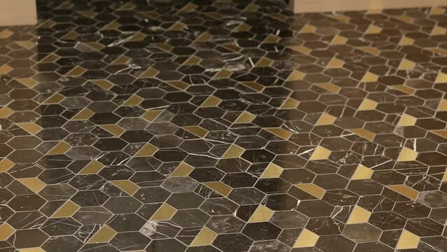 Renovated flooring in apartment with hexagon cells patchwork tiles in seamless vintage pattern with scuff textured effect in brown and sandy colours