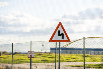 Traffic signs next to a fenced area