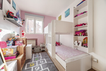 Bedroom with white wooden train bed with single beds at two heights and white aluminum window