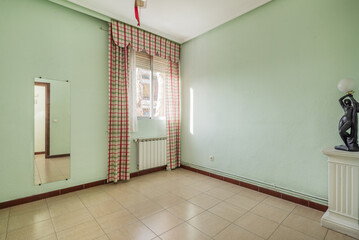 Empty room with a frameless mirror on the wall and window with eye-catching curtains on the window