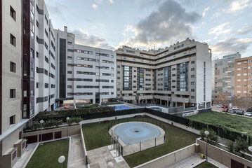 Common areas of buildings in an urbanization in a suburban neighborhood with swimming pools with protective tarps and gardens with grass