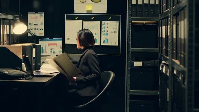 Private agent working in archive room at police to read official records or documents relevant to criminal case investigation. Detective officer conducting background check on suspects. Camera A.