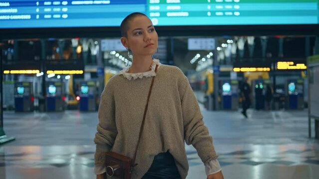 Stylish girl waiting train arrival at modern urban station close up zoom in.