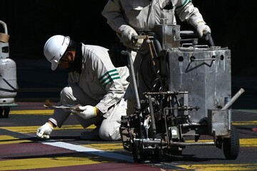 A scene of road marking line construction. Work to clarify the center line of the road with white...