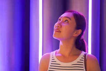 Happy beautiful Asian smart and good looking woman walking in the community mall at night.