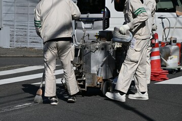 A scene of road marking line construction. Work to clarify the center line of the road with white...