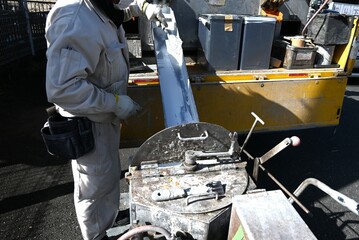 A scene of road marking line construction. Work to clarify the center line of the road with white...