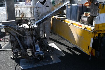 A scene of road marking line construction. Work to clarify the center line of the road with white...
