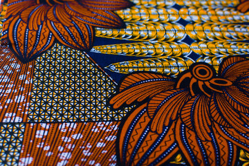 top view of orange ankara fabric, flatlay of nigerian wax cloth with designs, spread out orange...