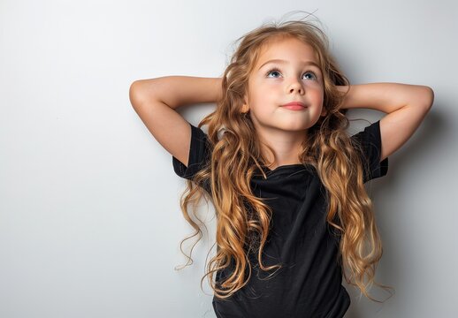 A cute little girl with long hair in a black blank t shirt  with a big empty space for text or product, Generative AI.
