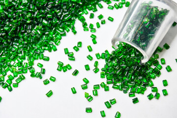 Transparent green masterbatch granules on a white background, this polymer is a colorant for...