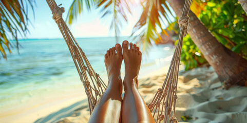 Close-up of bare feet in a hammock on a tropical beach with palm trees. - obrazy, fototapety, plakaty