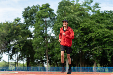 Attractive Young indian man wearing sportswear running on track at sport stadium. Asian Fit man...