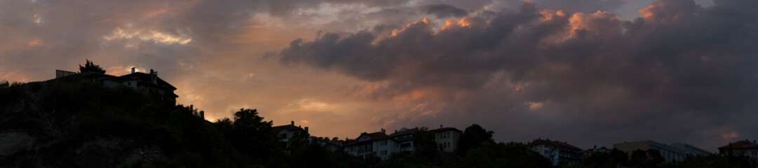 Colorful sunset over the Bulgarian town of Balchik. Cumulus clouds in a red-purple scale.